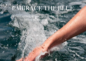 Hand running through blue water