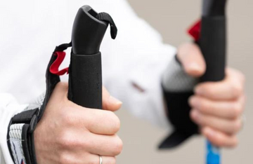 Close-up of hands holding walking poles.