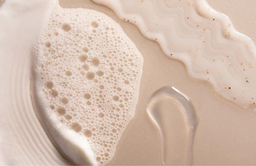 close up of bubbles and skincare on pink counter