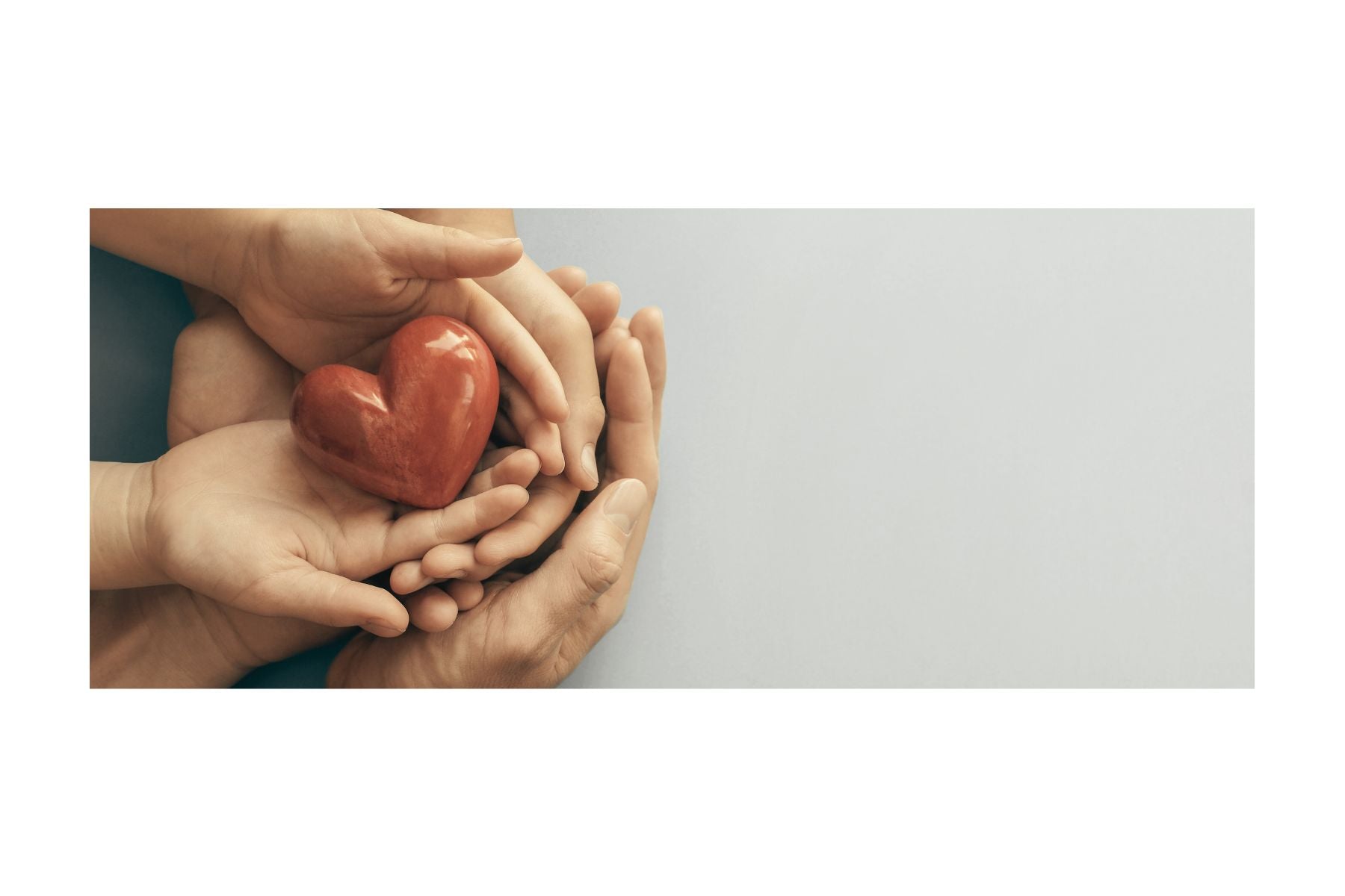 2 pairs of hands holding a ceramic heart